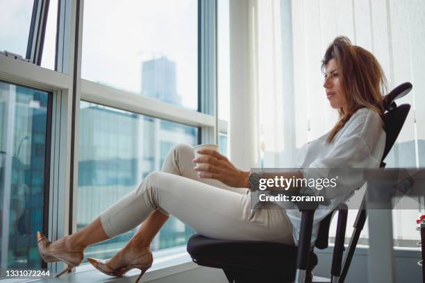businesswoman sitting in office chair in the morning, exhausted and stressed with work - exposto pelo vento imagens e fotografias de stock