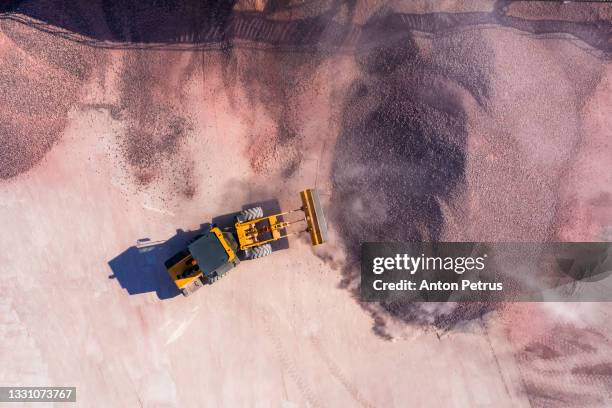 bulldozer unloads rubble at a construction site. aerial view - engin de chantier photos et images de collection