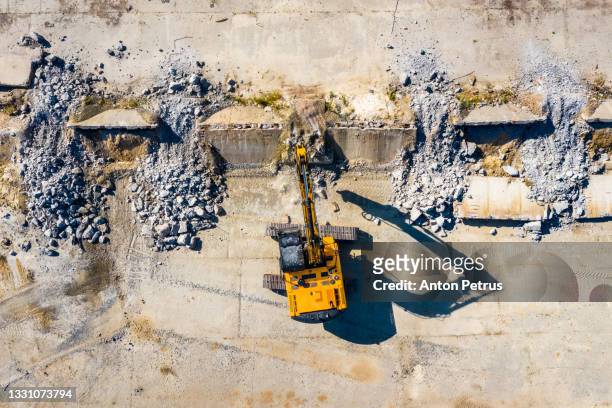 hydraulic hammer is demolishing concrete at a construction site. construction machinery - demolishing bildbanksfoton och bilder
