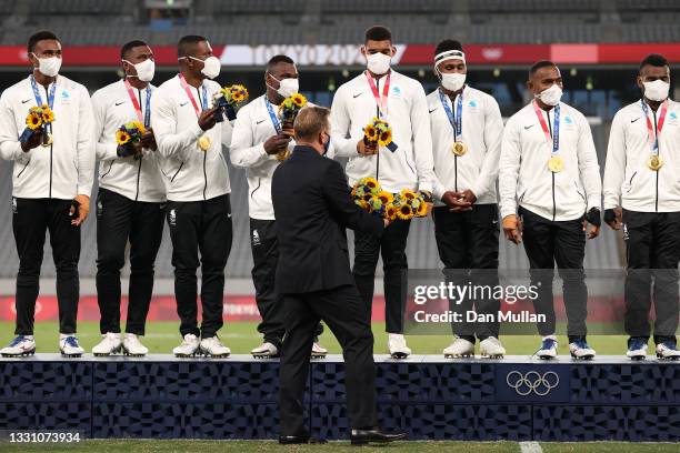 World Rugby CEO Alan Gilpin hands out flowers to Team Fiji after winning the Rugby Sevens Men's Gold Medal match between New Zealand and Fiji on day...