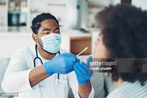 doctor testing a woman for covid-19 virus - coronavirus stock pictures, royalty-free photos & images
