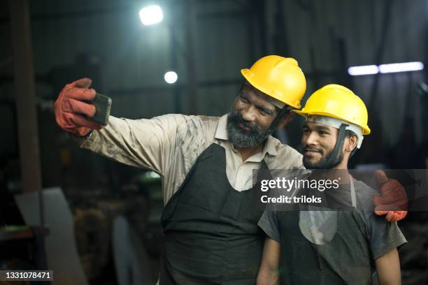 factory workers taking selfie using mobile phone - india phone professional stock pictures, royalty-free photos & images