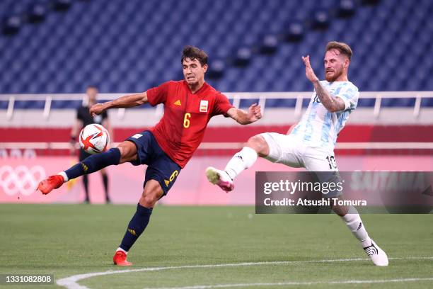 Martin Zubimendi of Team Spain shoots whilst under pressure from Alexis Mac Allister of Team Argentina during the Men's First Round Group C match...