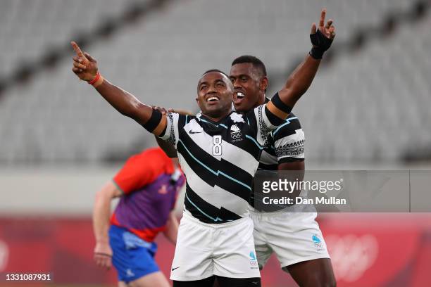 Waisea Nacuqu of Team Fiji celebrates victory with Kalione Nasoko of Team Fiji during the Rugby Sevens Men's Gold Medal match between New Zealand and...
