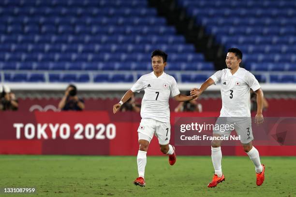 Takefusa Kubo of Team Japan celebrates with teammate Yuta Nakayama after scoring their side's first goal during the Men's Group A match between...