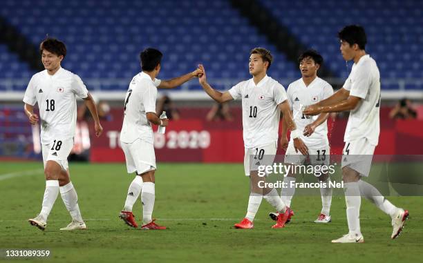 Takefusa Kubo of Team Japan celebrates with teammate Ritsu Doan after scoring their side's first goal during the Men's Group A match between France...