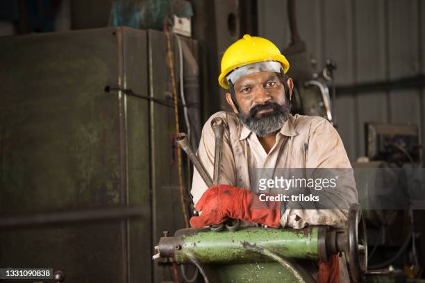 industriearbeiter mit blick auf die kamera - drehmaschine stock-fotos und bilder