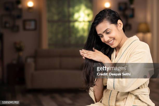 foto de una mujer joven en albornoz haciendo masaje capilar en casa - hair fotografías e imágenes de stock