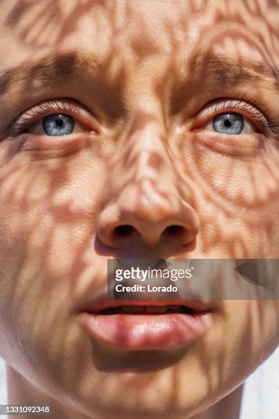 headshot of a female face behind summer shadow - naturlig skönhet bildbanksfoton och bilder