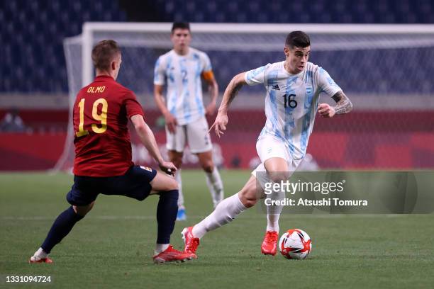 Martin Payero of Team Argentina runs with the ball whilst under pressure from Dani Olmo of Team Spain during the Men's First Round Group C match...
