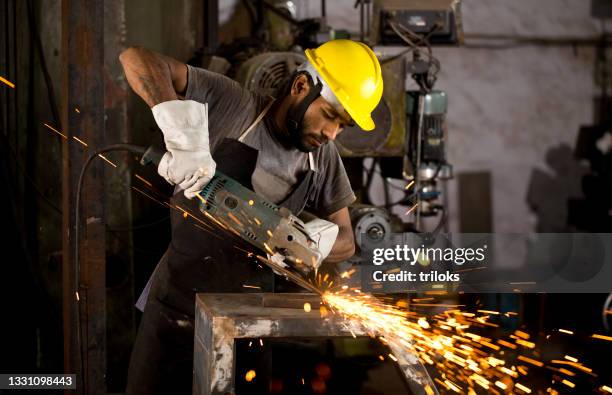 mechanic using circular saw grinder tool at factory - serra-circular imagens e fotografias de stock