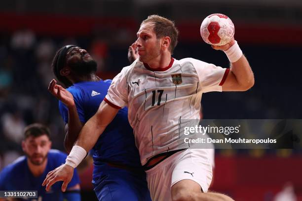 Steffen Weinhold of Team Germany looks to shoot as Dika Mem of Team France defends during the Men's Preliminary Round Group A handball match between...