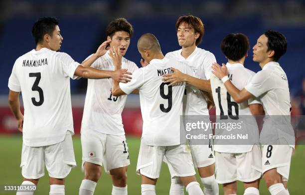 Daizen Maeda of Team Japan celebrates with Kou Itakura and teammates after scoring their side's fourth goal during the Men's Group A match between...