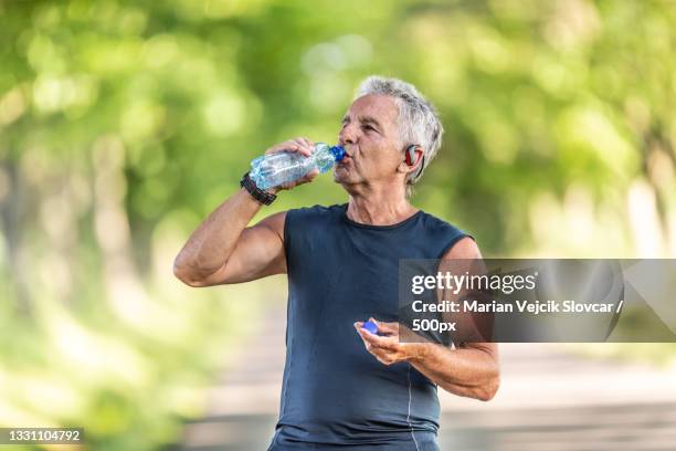 senior man drinking water from bottle - baby boomer stock pictures, royalty-free photos & images