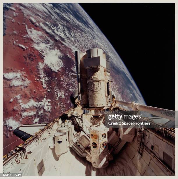 The cargo bay of Space Shuttle Endeavour, seen 190 nautical miles above the Earth, with the desert area of Namibia in the background, with the...