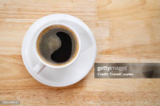 cup of coffee on a wooden table. cup of coffee with heart pattern in a white cup on wooden background - coffee cup from above stock pictures, royalty-free photos & images