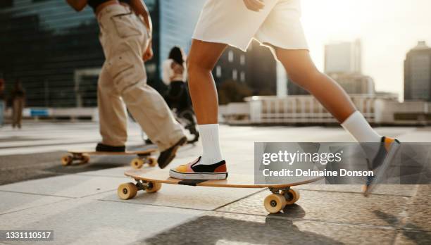 cropped shot of two unrecognizable women using skateboards in the city during the day - skateboarding stock pictures, royalty-free photos & images