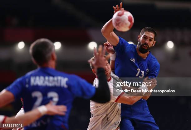 Nikola Karabatic of Team France passes the ball to teammate Luka Karabatic whilst being challenged by Steffen Weinhold of Team Germany during the...