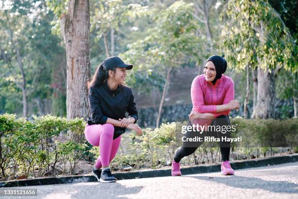 mother and daughter stretching out before running - malay archipelago stock pictures, royalty-free photos & images