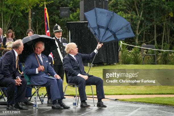 Prince Charles, Prince of Wales looks on as British Prime Minister, Boris Johnson opens his umbrella at The National Memorial Arboretum on July 28,...