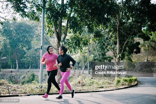 beautiful mother and daughter jogging together at the park - showus family stock pictures, royalty-free photos & images