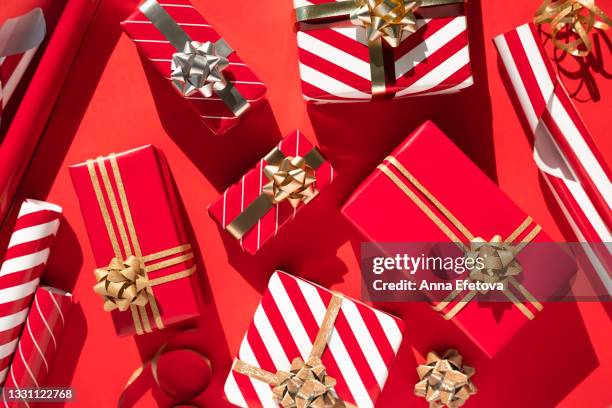 set of many white-red gift boxes, ribbon, bows and wrapping paper on red table. flat lay style - holiday gift stock-fotos und bilder