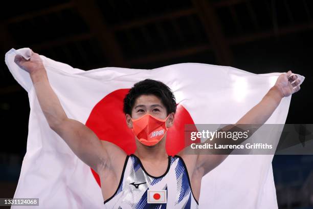Daiki Hashimoto of Team Japan celebrates his victory with the Japan Flag during the Men's All-Around Final on day five of the Tokyo 2020 Olympic...