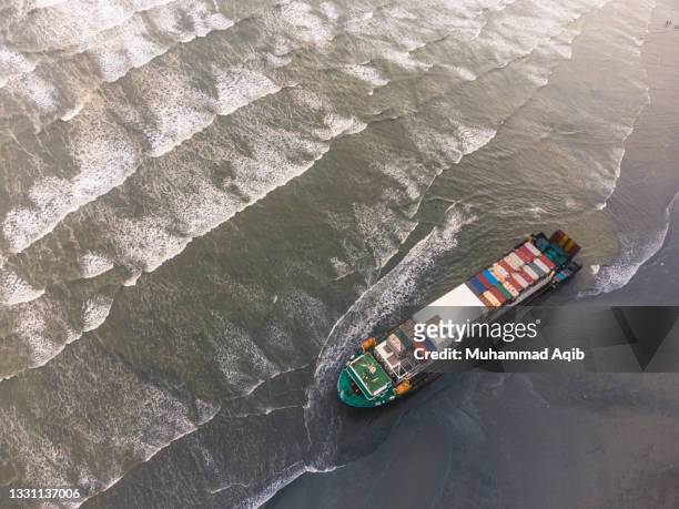 grounded ship stuck in shallow water of karachi - peu profond photos et images de collection