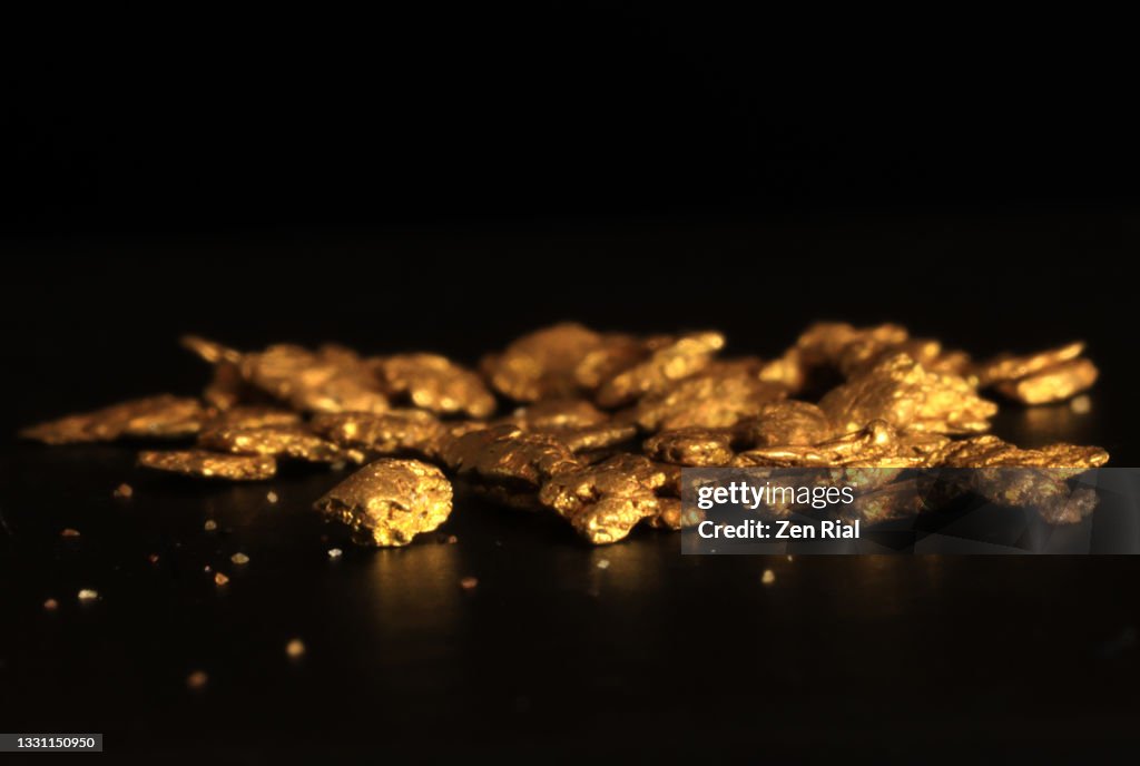 Collection of small gold nuggets on black background