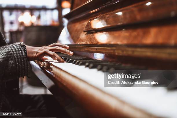 afrikanischer mann, der sanft klavier spielt - klavier stock-fotos und bilder