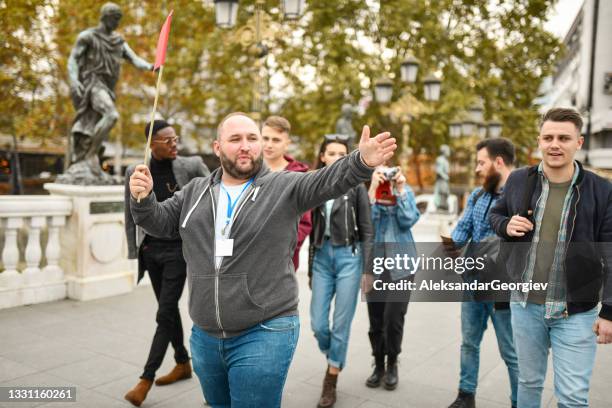 guía turístico calvo explicando los monumentos de manu al grupo turístico - guiding fotografías e imágenes de stock