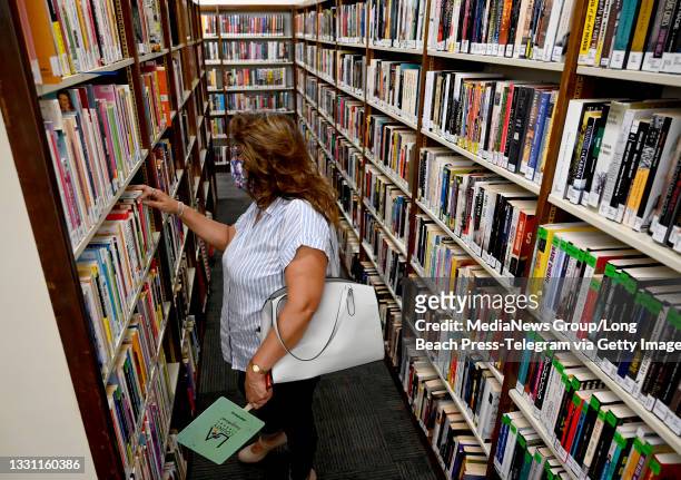 Woman browses the books at the grand reopening of the Maywood Cesar Chavez Library after pandemic closures and extensive renovations in Maywood on...