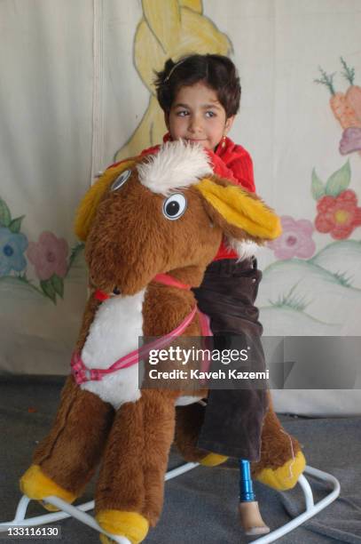Young girl who lost a limb when an earthquake struck the city plays in a tent in Bam, Iran, 8th November 2004. The 2003 Bam earthquake was a major...