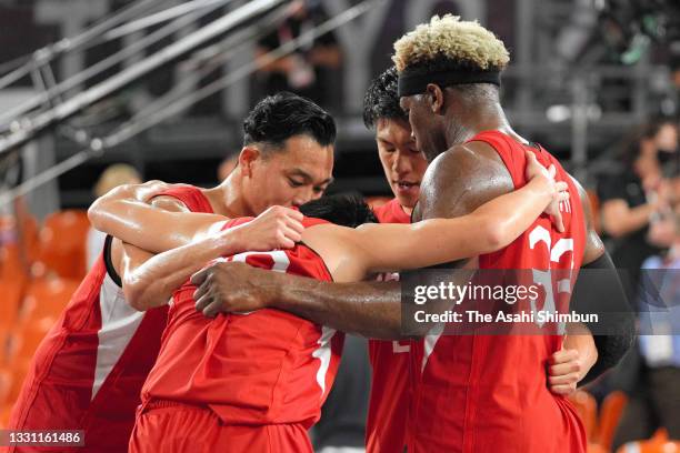Tomoya Ochiai, Keisei Tominaga, Ryuto Yasuoka and Ira Brown of Team Japan huddle after their defeat in the Men's 3x3 quarterfinal against Latvia on...