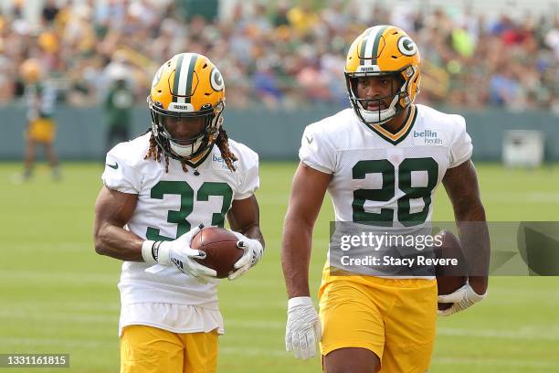 Aaron jones and AJ Dillon of the Green Bay Packers works out during training camp at Ray Nitschke Field on July 28, 2021 in Ashwaubenon, Wisconsin.