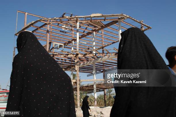 People pass by the skeleton of a building that survived the earthquake in Bam, Iran, 6th November 2004. The 2003 Bam earthquake was a major...