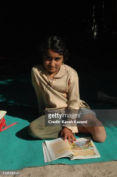 Young girl who lost a limb when the earthquake struck the city studies in a makeshift school in a tent in Bam, Iran, 8th November 2004. The 2003 Bam...
