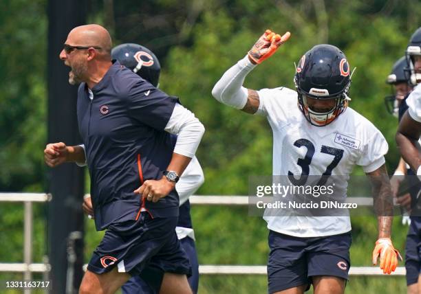 Head coach Matt Nagy of the Chicago Bears runs shouting across the field as Teez Tabor raises his arm during training camp at Halas Hall on July 28,...