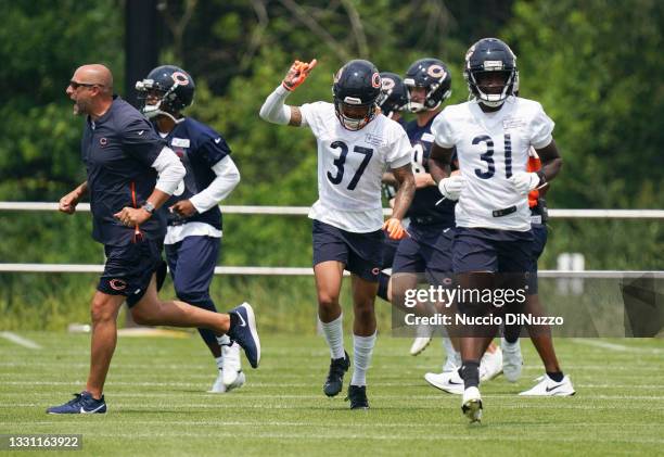 Head coach Matt Nagy of the Chicago Bears runs across the field as Teez Tabor raises his arm during training camp at Halas Hall on July 28, 2021 in...