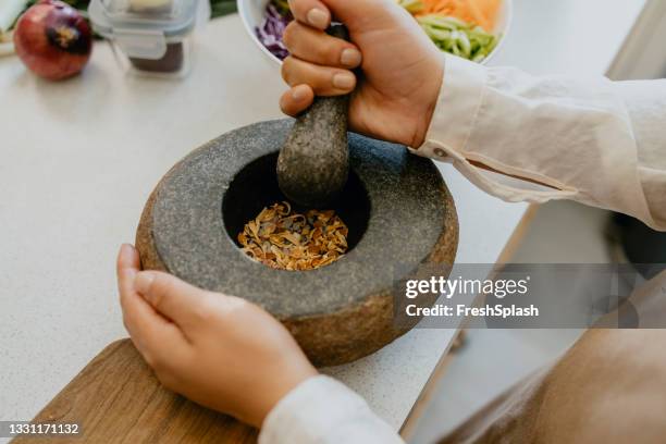 anonymous female chef preparing a tasty meal in the kitchen - mortar and pestle stock pictures, royalty-free photos & images