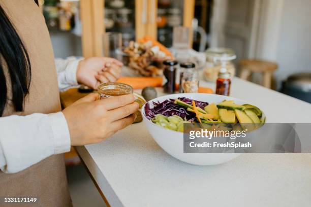 anonymous female chef preparing a tasty meal in the kitchen - olive oil splash stock pictures, royalty-free photos & images