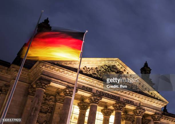 west portal of the reichstag building with german flag at night (berlin, germany) - bundestag imagens e fotografias de stock