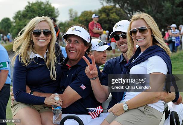 Amy Mickelson, Phil Mickelson, Hunter Mahan and Kandi Mahan of the U.S. Team ride off the course during the first round of The Presidents Cup at The...