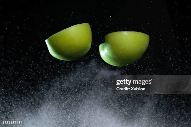 green apple flying in mid air - frozen apple fotografías e imágenes de stock