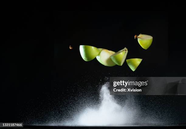 green apple flying in mid air - frozen apple fotografías e imágenes de stock