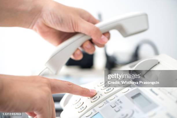 close up employee man hand touching handset of telephone on desk for contact customer or receiving call , hotline concept - telephone switchboard stock pictures, royalty-free photos & images