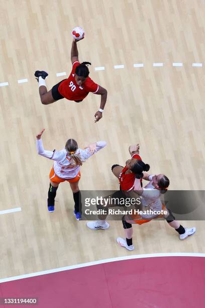 Isabel Guialo of Team Angola shoots at goal over the top of Kelly Dulfer of Team Netherlands during the Women's Preliminary Round Group A handball...