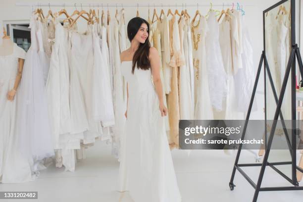 asian women  try wedding dresses . - bridal shop stock pictures, royalty-free photos & images
