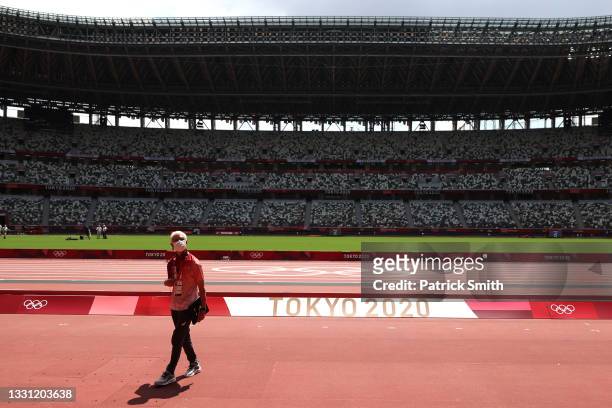 Passerby looks on while wearing a protective face covering due to the Covid-19 pandemic inside the Olympic Stadium, host to the Athletics...