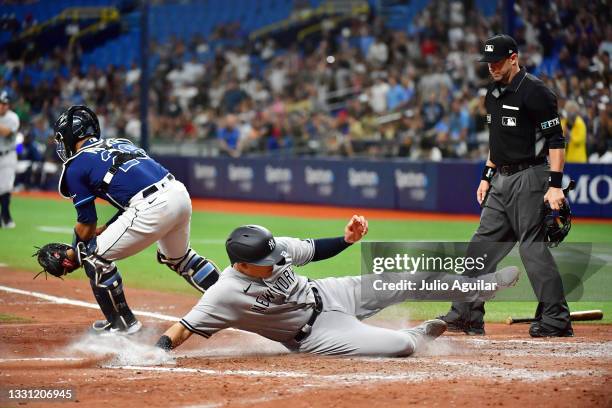 Gio Urshela of the New York Yankees slides into home base after DJ LeMahieu hit a sacrifice fly in the fifth inning against the Tampa Bay Rays at...